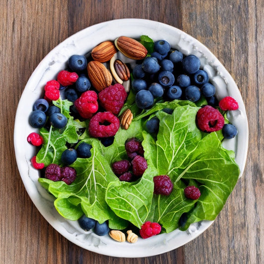 a bowl with leafy greens, berries, nuts and seeds